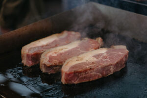 Foto von drei Steaks auf einem Grill